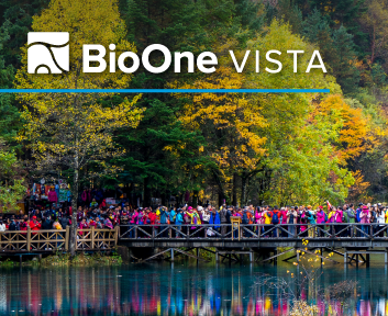 BioOne VISTA. Autumn trees reflected in water with a wooden bridge and a crowd of tourists